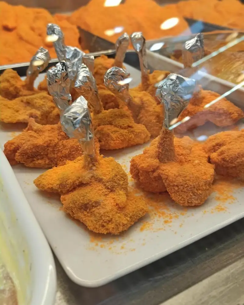 سینی آماده از لالی پاپ‌های مرغ سوخاری و مزه‌دار با پودر نارنجی، آماده طبخ در سوپر پروتئین ملل برای مهمانی‌ها و فینگرفود