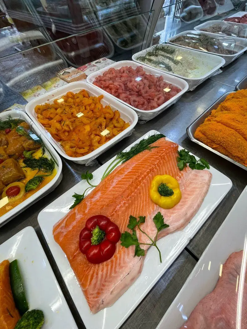 تنوع محصولات تازه و پروتئینی سوپر پروتئین ملل شامل فیله سالمون، میگوهای آماده و غذاهای دریایی با کیفیت بالا در فروشگاه.