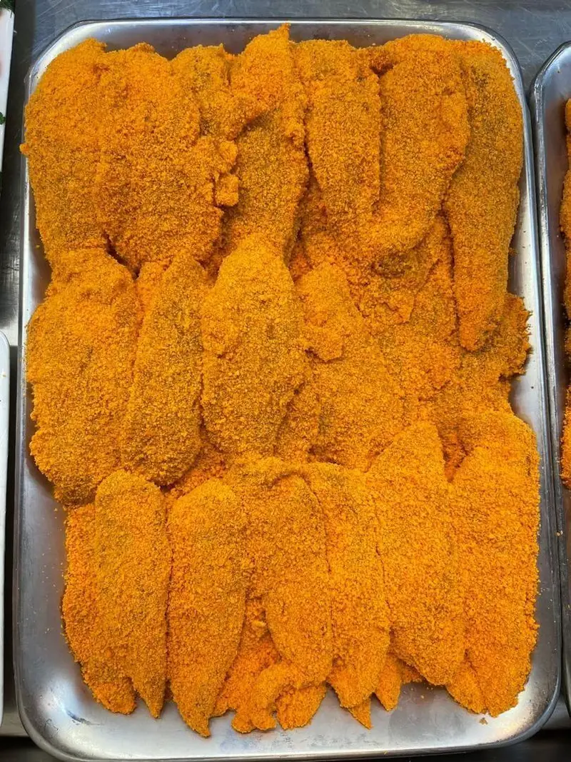 فیله‌های آماده طبخ ماهی یا مرغ سوخاری با روکش نارنجی و ترد در سینی، بهترین محصولات پروتئینی سوپر پروتئین ملل.