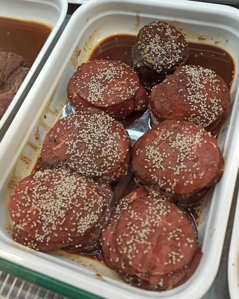 گوشت‌های استیکی ممتاز و دست‌چین سوپر پروتئین ملل، کاملاً مرینیت شده با دانه کنجد، آماده طبخ برای طعمی بی‌نظیر.