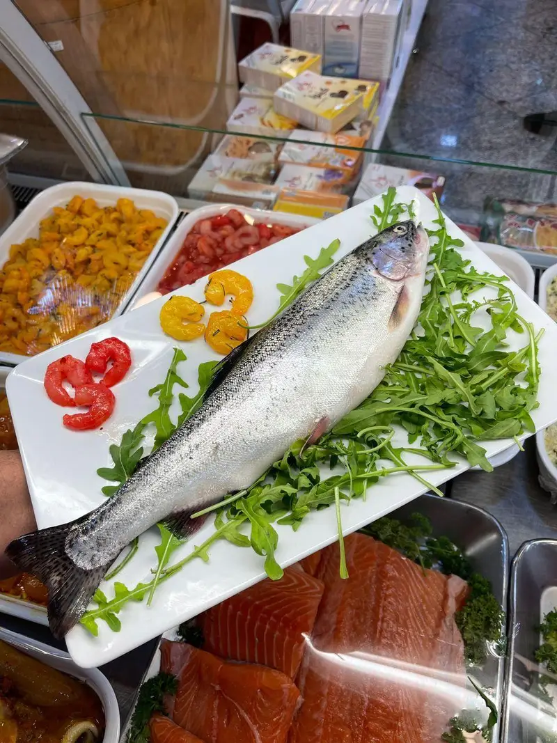 نمایی از ماهی قزل آلا تازه، میگوهای خوشرنگ و فیله سالمون باکیفیت در بخش غذاهای دریایی سوپر پروتئین ملل.