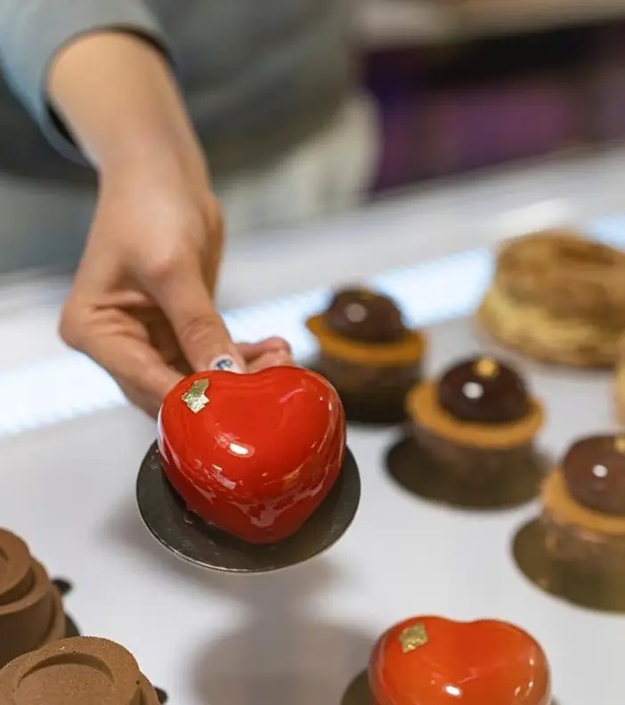 دسر قلبی قرمز و براق با برگ طلا، آماده سرو در کافه لوندر. شیرینی‌های خاص و خوشمزه برای لحظات شیرین شما در کافه.