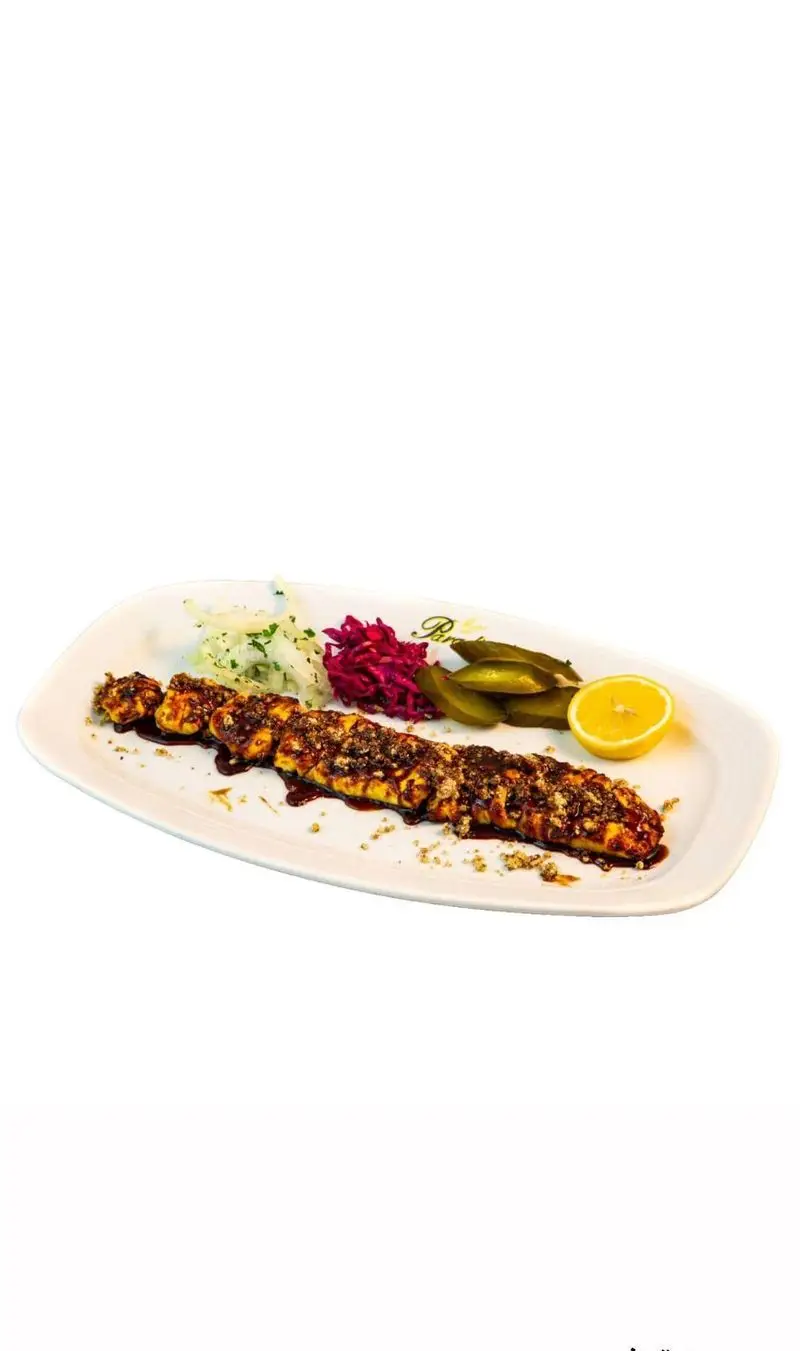 سینی کباب مخصوص رستوران کلاسیک پردیس، دارای کباب با سس ویژه و تزئینات مغز پسته، سرو شده با پیاز، کلم قرمز، خیارشور و لیمو تازه.