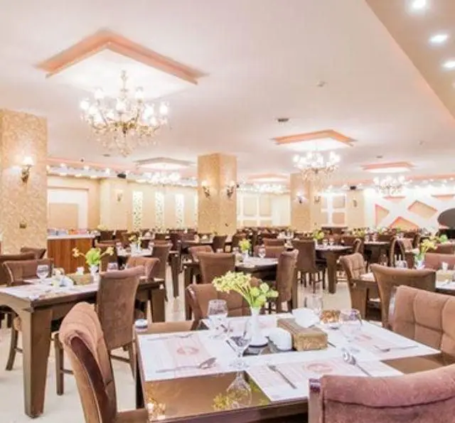 سالن بزرگ و زیبای رستوران کلاسیک پردیس، با دکوراسیون کلاسیک، میزهای چیده شده و آماده برای سرو غذا و پذیرایی از مهمانان.