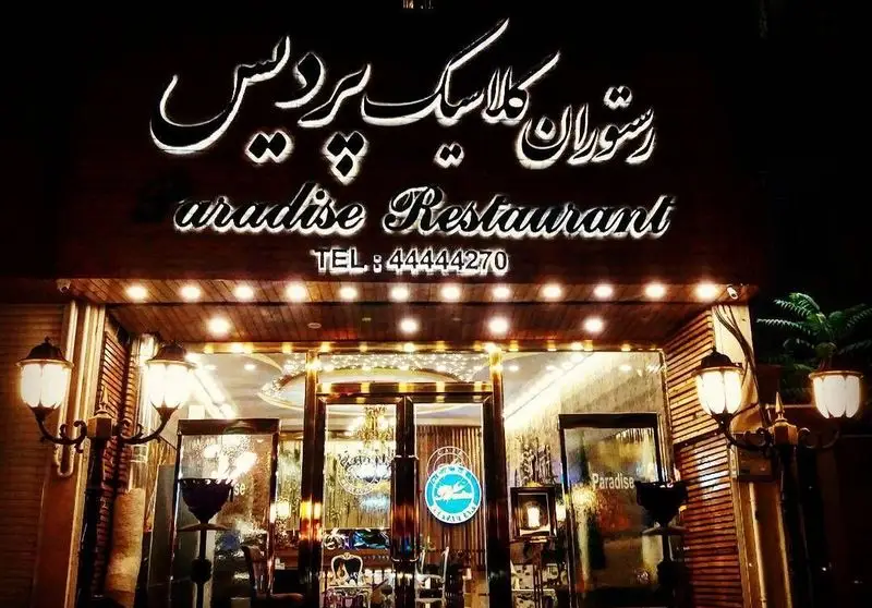 تصویر نمای بیرونی روشن و لوکس رستوران کلاسیک پردیس در شب، با تابلوی بزرگ فارسی و لاتین، و شماره تلفن ۴۴۴۴۴۲۷۰ جهت رزرو.