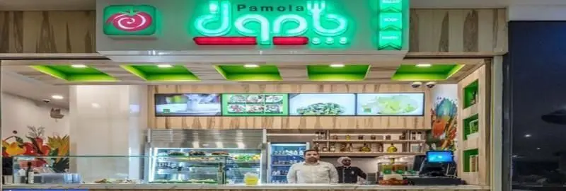 نمایی از رستوران غذای سالم پامولا با منوی متنوع سالاد و غذاهای رژیمی، همراه با کانتر شیک و کارکنان آماده سرویسدهی.