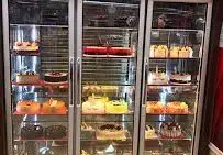 نمایی از سه یخچال ویترینی مملو از انواع کیک، شیرینی و دسرهای تازه در قنادی شیرینی و آجیل گلستان برای مشتریان.