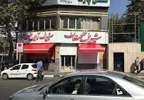 نمای خارجی فروشگاه شیرینی و آجیل گلستان با تابلوهای قرمز و سفید. مقصدی ایده‌آل برای خرید شیرینی، آجیل و دسر با کیفیت در شهر.