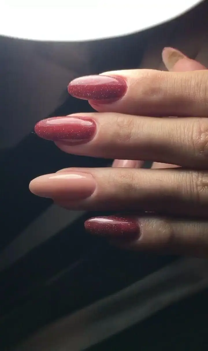 طراحی ناخن شیک با لاک اکلیلی زرشکی و تک ناخن کرم نود ساده، مناسب برای ایده کاشت ناخن و ژلیش دخترانه در سالن زیبایی