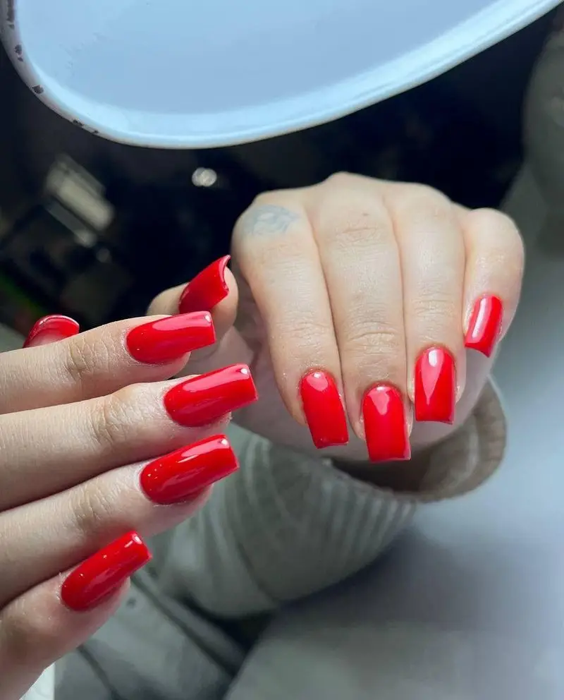 نمونه کار کاشت ناخن مربعی با لاک ژل قرمز جیغ و براق، اجرا شده توسط ناخن‌کار حرفه‌ای در سالن و مرکز زیبایی مریم موسوی