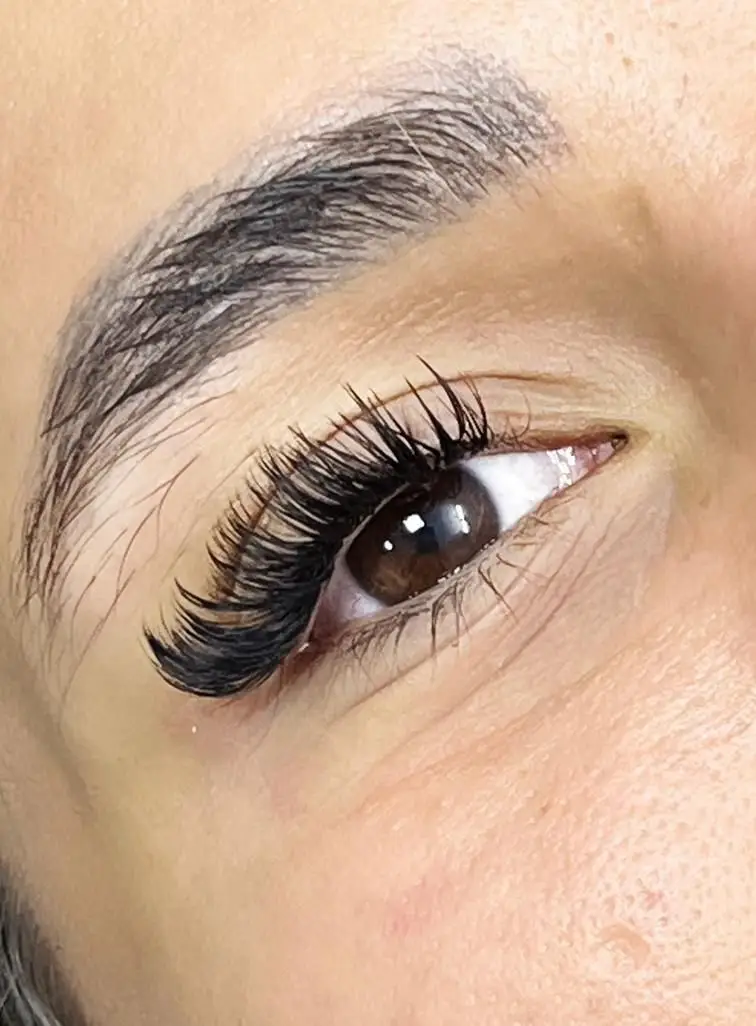 نمای نزدیک از چشم با مژه‌های والیوم بلند و پرپشت و ابروی مرتب. این تصویر خدمات اکستنشن مژه را در مرکز زیبایی مریم موسوی نشان می‌دهد.