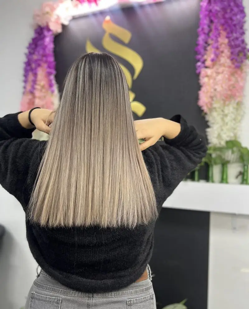 جدیدترین مدل رنگ و لایت موی دخترانه با تکنیک بالیاژ نسکافه‌ای و دکلره حرفه‌ای روی موهای صاف و بلند در سالن زیبایی