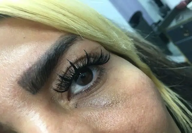 تصویر نمای نزدیک از چشم قهوه‌ای و ابروی یک خانم با خدمات اکستنشن مژه والیوم مشکی و پرپشت در مرکز زیبایی مریم موسوی