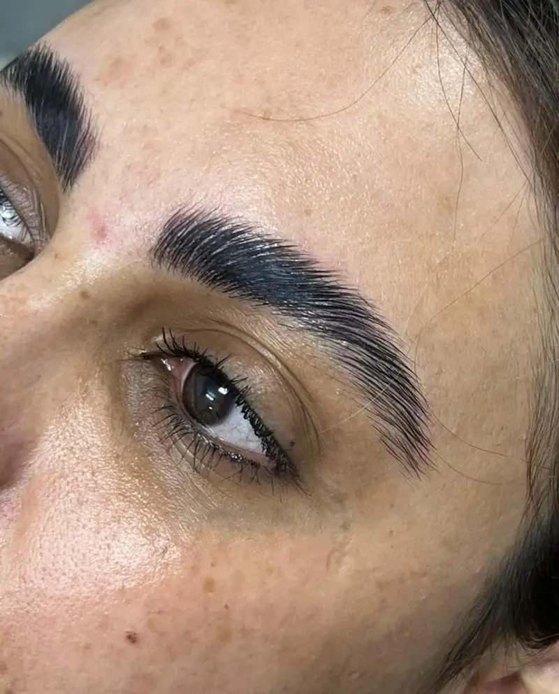 تصویر نزدیک از مراحل انجام لیفت و لمینت ابرو دخترانه با مواد ارگانیک جهت تقویت و پرپشت نشان دادن ابروها در سالن زیبایی