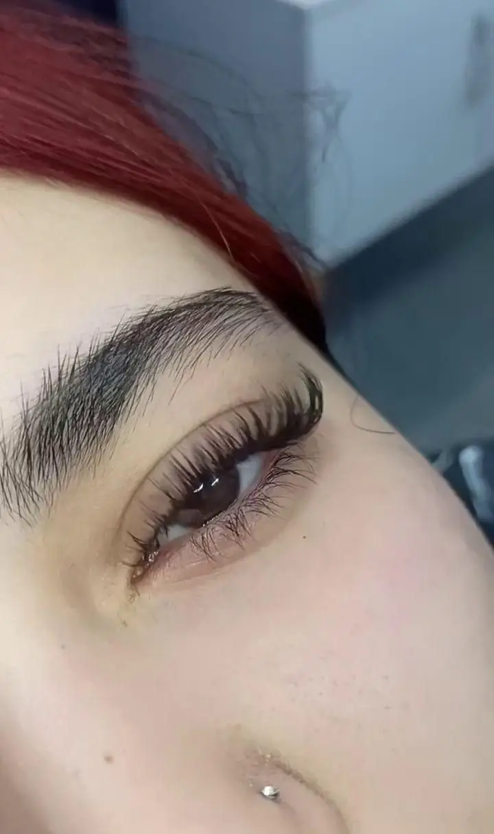 تصویر نزدیک از اکستنشن مژه والیوم با تراکم بالا و حالت طبیعی به همراه ابروهای مرتب شده در سالن زیبایی تخصصی مژه