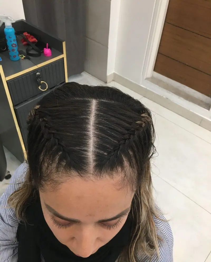 تصویری از بالای سر یک خانم با موهای مشکی فرق وسط که دو طرف جلوی موها به صورت ظریف بافته شده است در مرکز زیبایی مریم موسوی