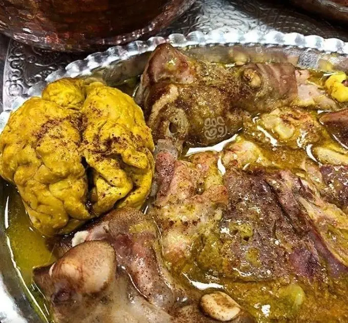 تصویری از کله پاچه سنتی و لذیذ طباخی چیذر با مغز و گوشت گوسفند تازه در ظرف نقره‌ای، غذایی پرانرژی برای صبحانه.