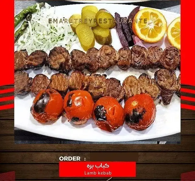 سرو کباب بره لذیذ و سنتی ایرانی با گوجه کبابی و مخلفات تازه در رستوران ایرانی عمارت. غذای اصیل و باکیفیت.