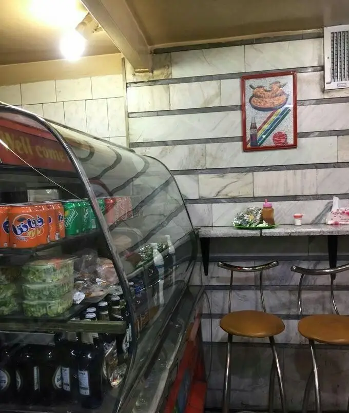 نمای داخلی پیتزا پل با ویترین پر از نوشیدنی‌ها، سالادهای آماده و محصولات غذایی در محیطی تمیز و دلنشین، ایده‌آل برای صرف فست فود.