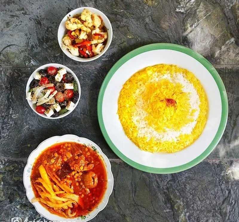 غذای سنتی ایرانی از کافه سینان: خورش غنی با سیب زمینی سرخ شده، برنج خوش عطر زعفرانی و دو نوع سالاد تازه و رنگارنگ.