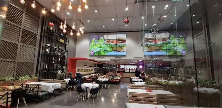 فضای داخلی مدرن و جادار رستوران پرپروک، با نمایشگر بزرگ ساندویچ و سبزیجات تازه، میزهای چوبی و دکوراسیون شیک برای مشتریان.