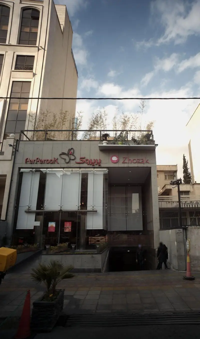 نمای بیرونی شعبه رستوران پرپروک و ژوژک، ارائه دهنده فست فود و پیتزا، با تابلوی مشخص و ورودی شیشه‌ای.