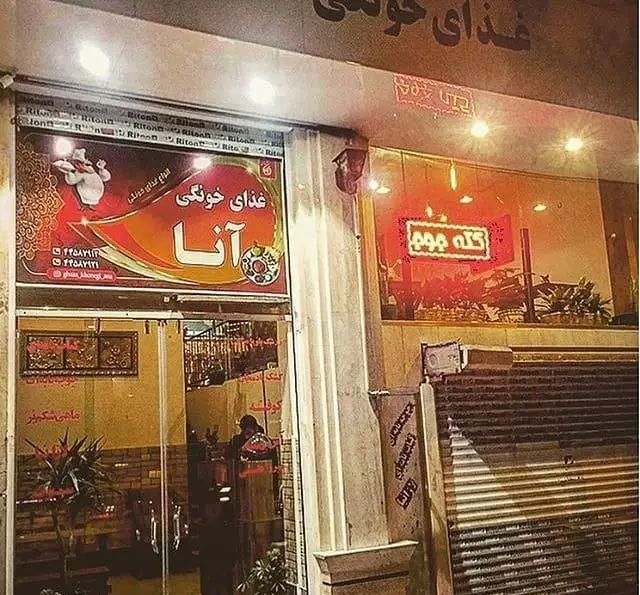 نمای شب از تهیه غذای "آنا" با تابلوی "غذا خونگی آنا" و شف کارتونی، ارائه دهنده غذاهای سنتی و خانگی ایرانی با امکان سفارش.