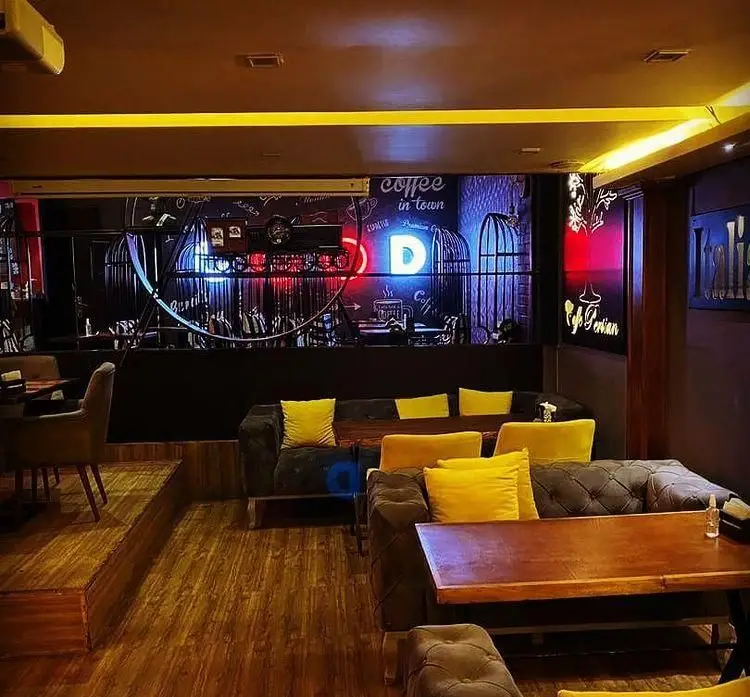 فضای داخلی دنج و مدرن کافه رستوران پرشین با مبلمان راحت، میزهای چوبی و نورپردازی نئونی؛ محیطی ایده آل برای دورهمی.