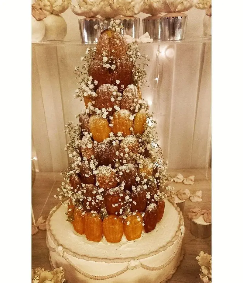 برج دسر مجلل گروه تشریفاتی lemon با تزیین گل و پودر قند، انتخابی ایده‌آل برای مراسم و جشن‌های خاص. خدمات تشریفات مجالس.