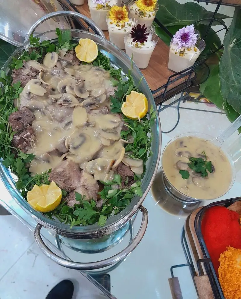 میز پذیرایی لوکس گروه تشریفاتی لیمون شامل بشقاب بزرگ گوشت با سس قارچ، سبزیجات تازه و لیمو، همراه با دسرهای شیک و فینگرفود.