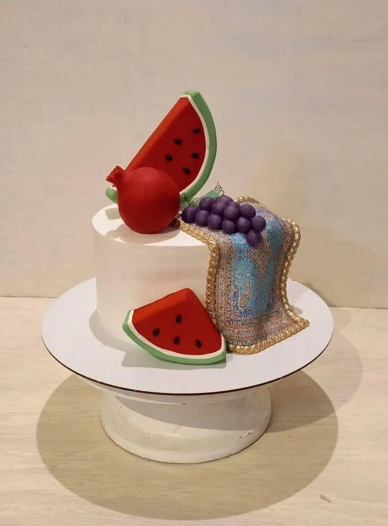 کیک مدرن و خاص شب یلدا از گروه تشریفاتی لیمون، تزئین شده با هندوانه، انار، انگور و طرح قالی سنتی زیبا برای یلدا.
