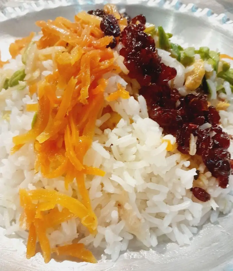 مرصع پلو مجلسی و خوش‌رنگ با زرشک، هویج، خلال پسته و برنج ایرانی، آماده شده توسط گروه تشریفاتی لیمون برای مهمانی‌ها و مراسم شما.