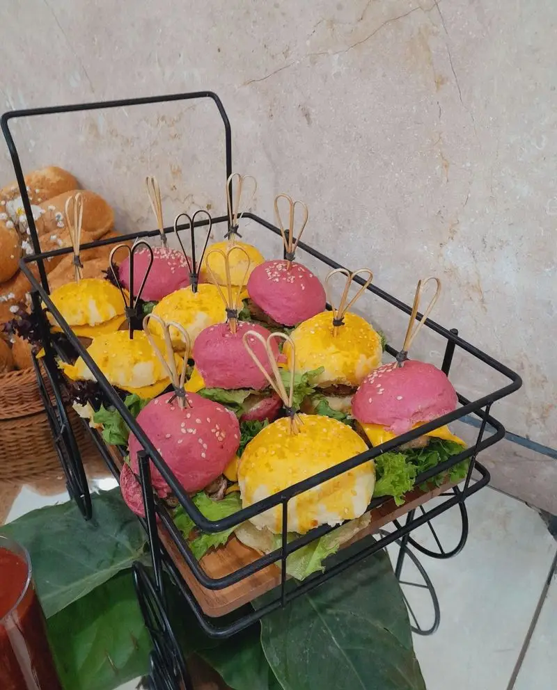 گروه تشریفاتی lemon: مینی برگرهای اسلایدر رنگی (صورتی و زرد) با دیزاین شیک در سبد چرخدار فینگرفود برای مجالس و پذیرایی خاص.