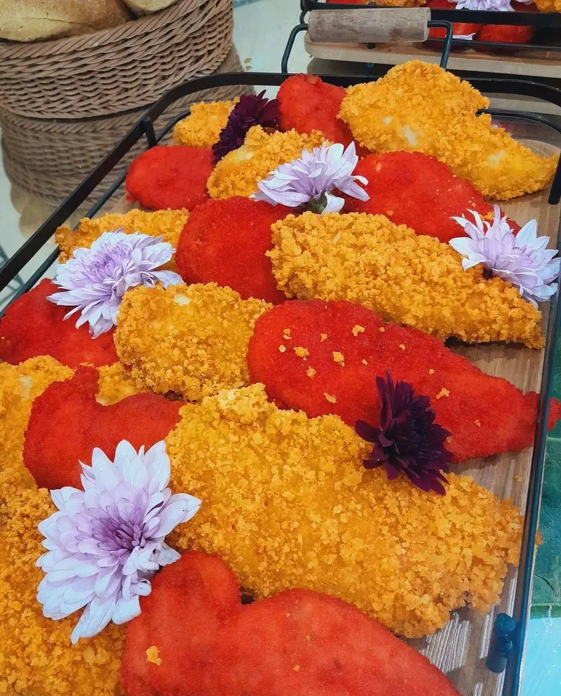 سینی غذای رنگارنگ گروه تشریفاتی lemon شامل غذاهای سوخاری قرمز و زرد، تزئین شده با گل. مناسب پذیرایی مجالس و مهمانی‌ها.