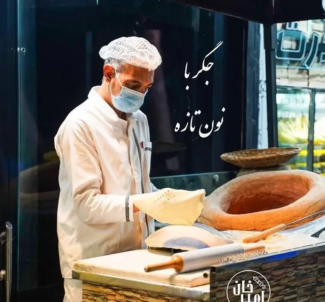 آشپز جگرسرای امیرخان (گل یخ) مشغول پخت نان تازه و داغ در تنور سنتی، تضمین‌کننده طعم بی‌نظیر جگر با نان گرم.