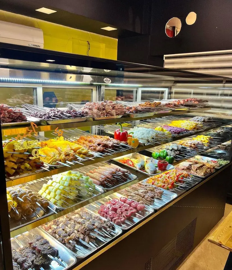 نمایش ویترین جگرسرای امیرخان (گل یخ) با سیخ‌های متنوع کباب جگر، گوشت، مرغ، ماهی و سبزیجات تازه آماده طبخ در محیط رستوران.