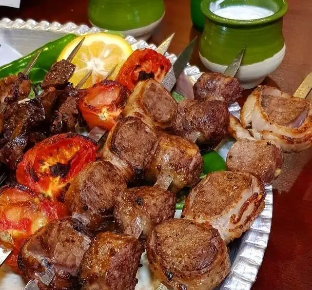 سینی کباب‌های داغ و خوشمزه جگر، دل، قلوه و چنجه به همراه گوجه و فلفل کبابی، آماده سرو در جگرسرای امیرخان (گل یخ).