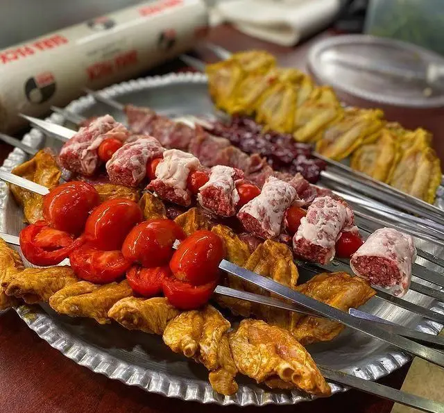 سینی متنوع کباب با سیخ‌های جگر، کباب کوبیده، بال مرغ زعفرانی و گوجه فرنگی تازه، آماده پخت در جگرسرای امیرخان (گل یخ).