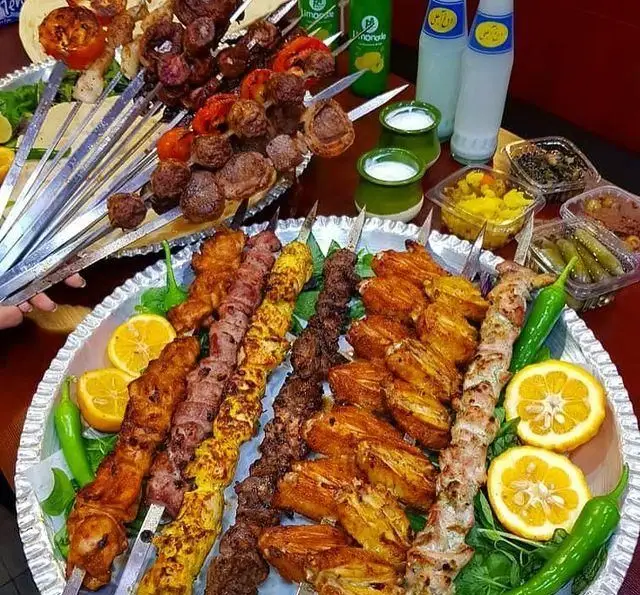 میز پر از کباب‌های لذیذ جگر، کوبیده، جوجه، بال و چنجه در جگرسرای امیرخان (گل یخ)؛ بهترین کباب سنتی ایرانی همراه با مخلفات.