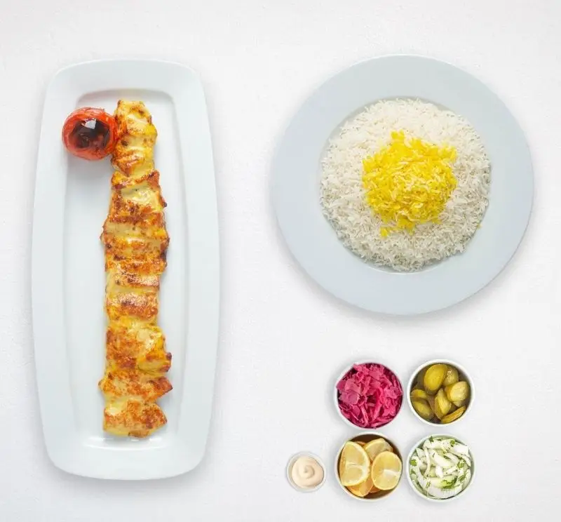 چلو جوجه کباب لذیذ با برنج زعفرانی، گوجه کبابی و مخلفات از کترینگ چامه. غذای سنتی ایرانی هایپر کترینگ چامه.