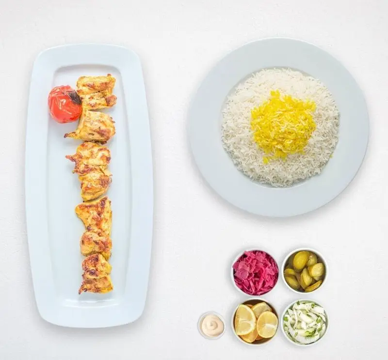 جوجه کباب زعفرانی با چلو برنج زعفرانی، گوجه کبابی و مخلفات متنوع شامل ترشی، خیارشور و لیمو در هایپر کترینگ چامه