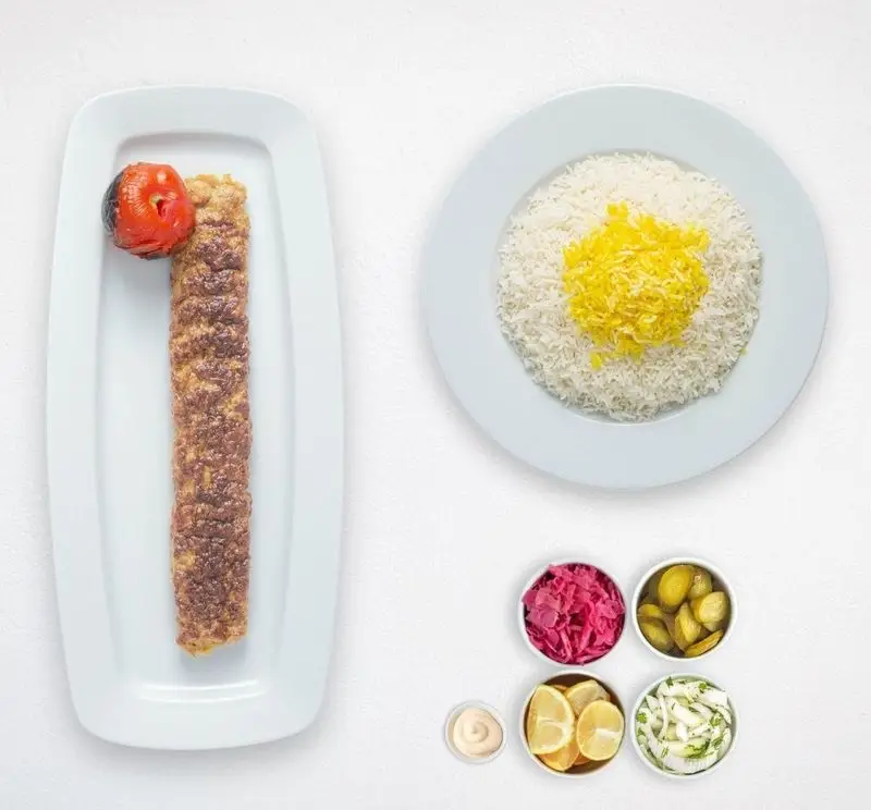 چلو کباب کوبیده خوشمزه با برنج زعفرانی، گوجه کبابی و انواع مخلفات در هایپر کترینگ چامه. تجربه غذای ایرانی