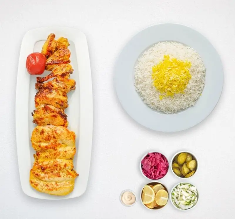 چلو جوجه کباب مخصوص هایپر کترینگ چامه، غذایی محبوب با تکه‌های مرغ کبابی، برنج، گوجه و دورچین‌های متنوع و تازه.