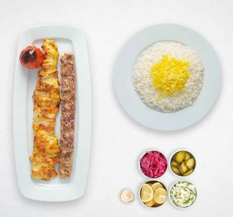 تصویری از چلوکباب لذیذ ایرانی: جوجه کباب و کباب کوبیده با برنج زعفرانی و مخلفات کامل از هایپر کترینگ چامه.