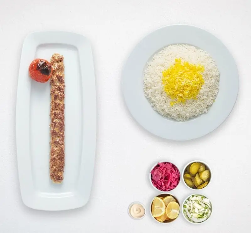 کباب کوبیده و برنج زعفرانی با گوجه کبابی و مخلفات ترشی کلم، خیارشور و لیمو. غذای اصیل ایرانی هایپر کترینگ چامه.