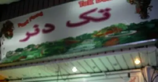 تابلوی ورودی رستوران ساندویچ تک دنر در شب، با فونت فارسی برجسته و طرح جذاب، مناسب برای غذای آماده.