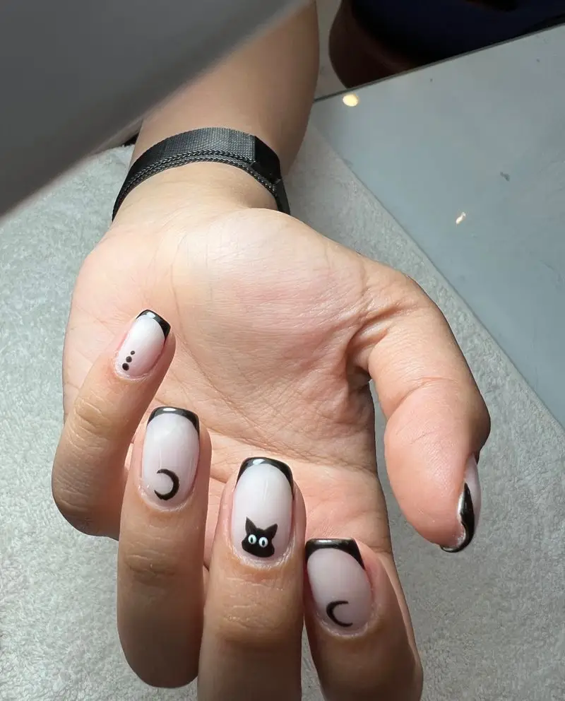 طراحی ناخن مشکی و سفید با طرح گربه و ماه، به سبک فرنچ، نشان‌دهنده ظرافت و توجه به جزئیات در رستوران ایتالیایی فینیتو.