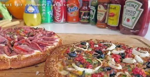 دو پیتزای خوشمزه فست فود با سس‌ها و نوشیدنی‌های متنوع، مناسب منوی فست فود مرغ سوخاری دی.