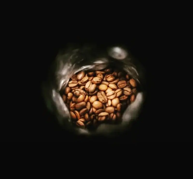 نمایی نزدیک از دانه های قهوه بوداده و معطر کافه سامیا در بسته بندی، نشان دهنده کیفیت برتر و تازگی محصولات ما برای تجربه ای دلنشین.