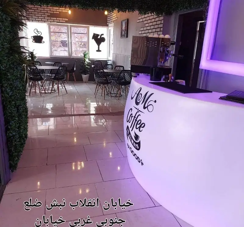 فضای داخلی مدرن کافه قلیان عربی A&M در خیابان انقلاب، با پیشخوان نورانی، میز و صندلی‌های شیک برای قهوه و قلیان.